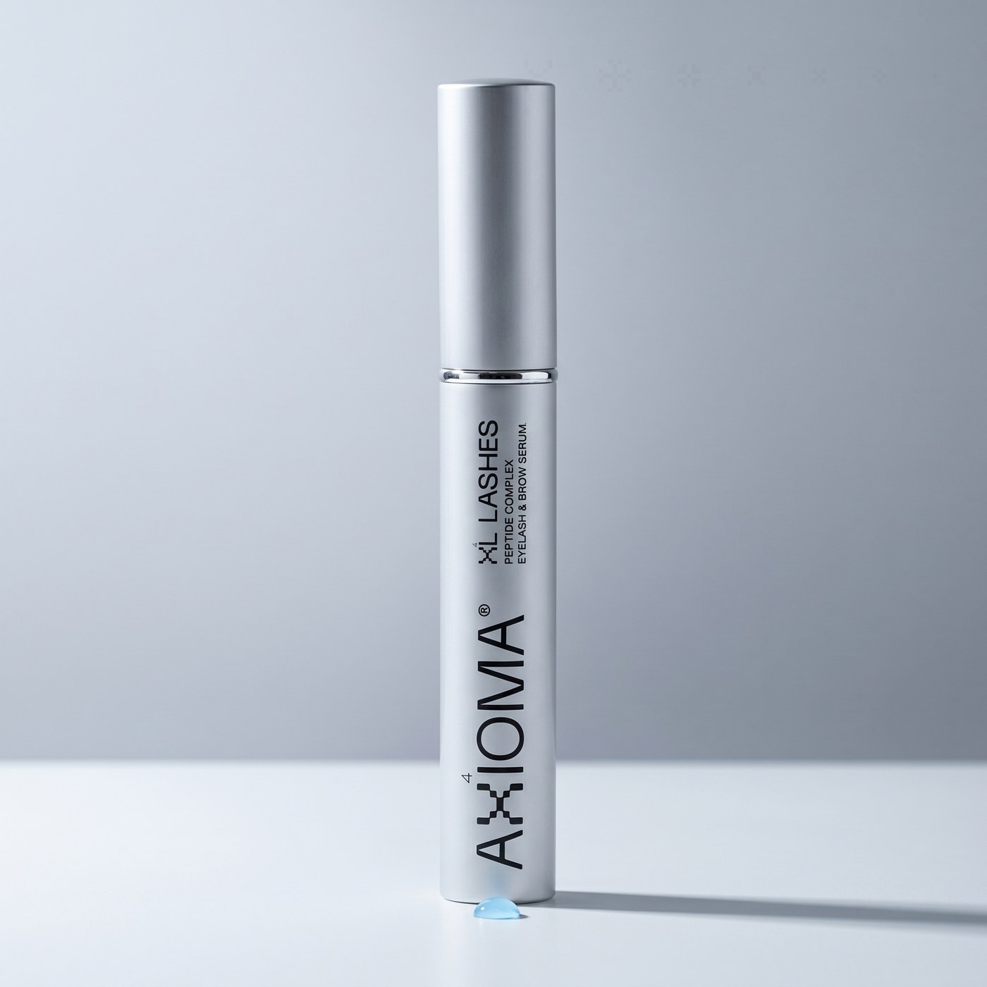 Sérum XL Lashes de AXIOMA — tubo plateado, fotografía de producto premium clean biotech.